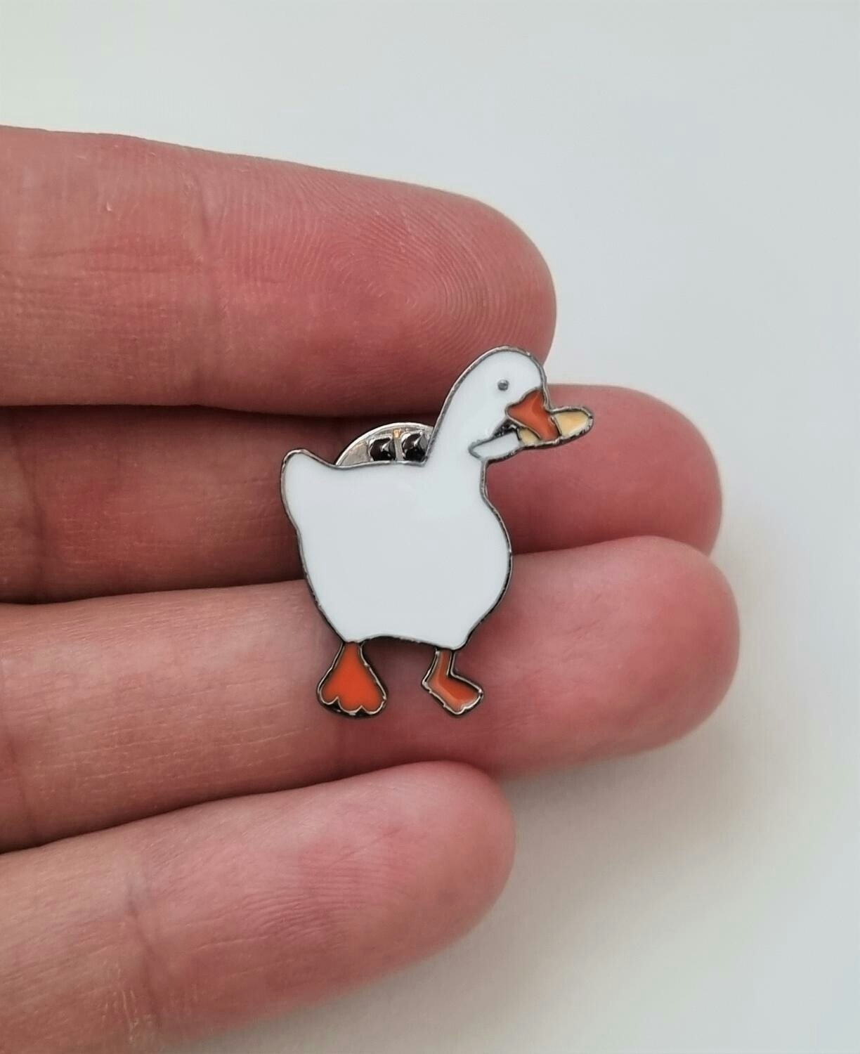 Pins, anka / gås med en kniv i munnen