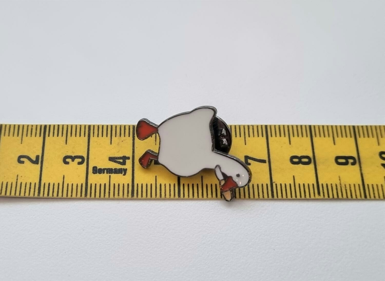 Pins, anka / gås med en kniv i munnen