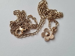 Halsband med en rosa liten blomma