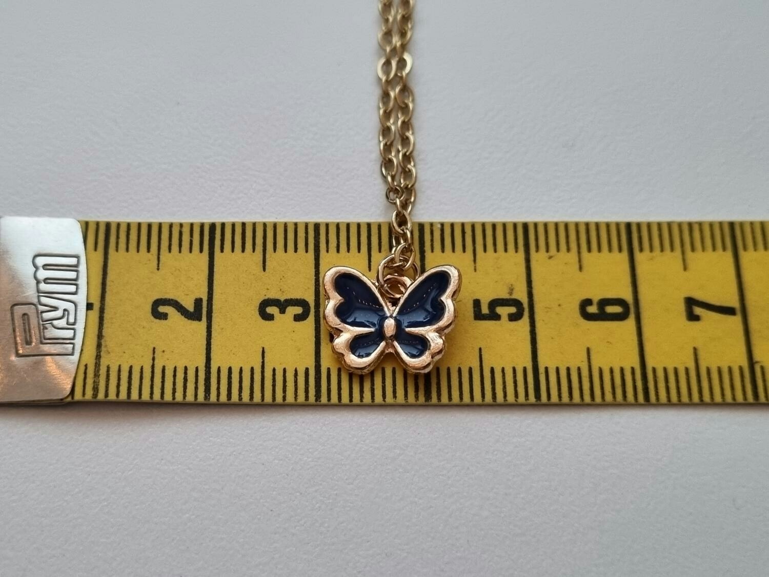 Guldfärgat halsband med en svart fjäril / fjärilsberlock
