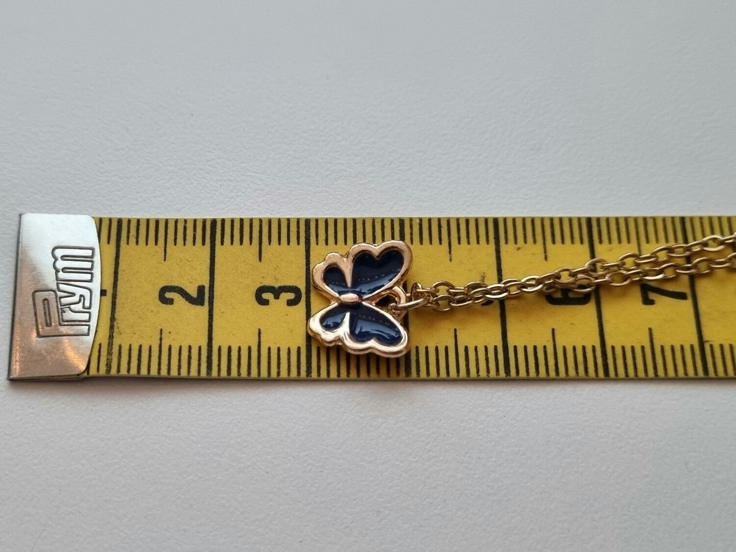 Guldfärgat halsband med en svart fjäril / fjärilsberlock