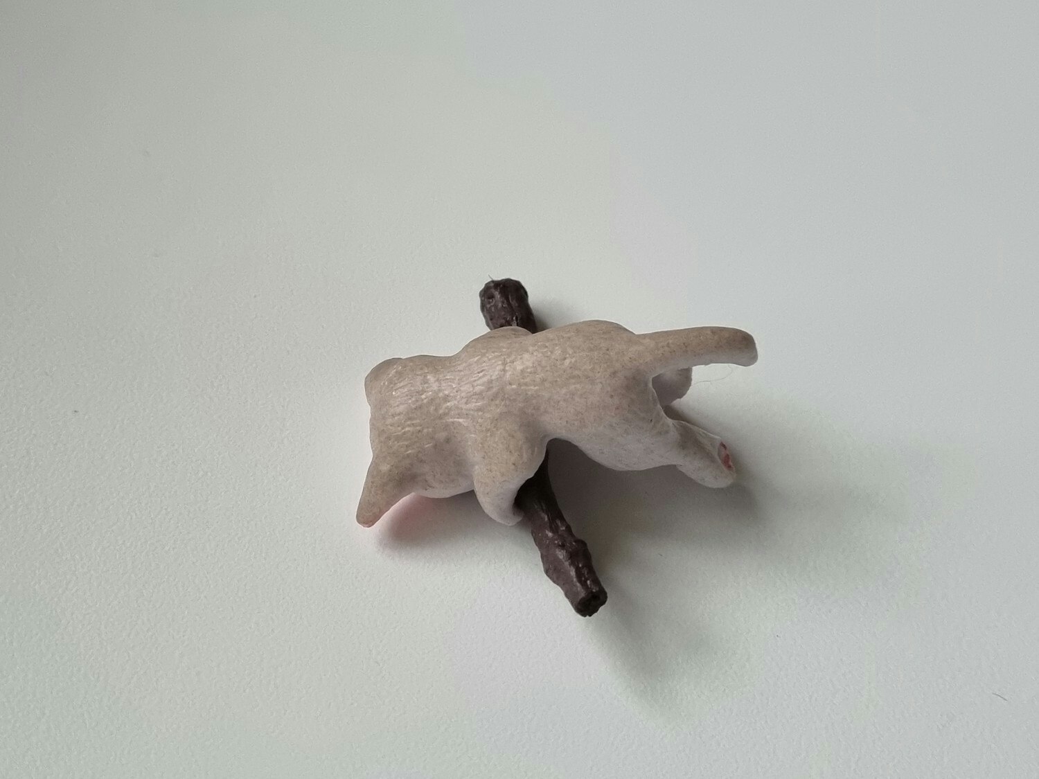 Gullig katt som klamrar sig fast vid en gren / miniatyr