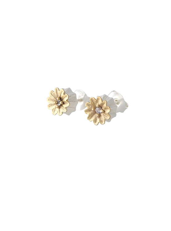 Poppy Stud Earrings från Lotta Jewellery är tillverkade i frostat silver och dekorerade med 14 k matt guld och glittrande vita safirer.
