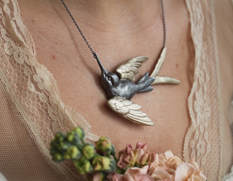 Fluttering Swallow Halsband från Lotta Jewellery är gjort i brons med dekorationer i 14 k guld. Genom att låta vita safirer utgöra ögonen på svalan har vi gett den vackra fågeln lite extra karaktär. D