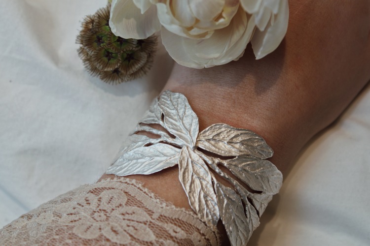 Armbandet är gjort av frostat silver och består av vackra blad och grenar som elegant virar sig runt handleden.
