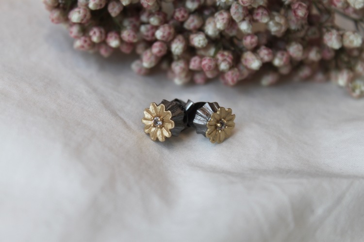 Poppy Stud Earrings från Lotta Jewellery är tillverkade i brons och dekorerade med 14 k matt guld och glittrande vita safirer.