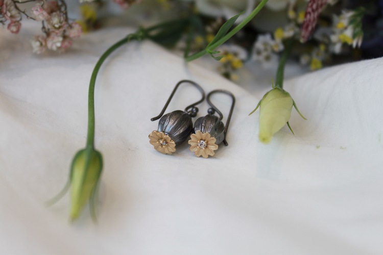 Poppy Earrings från Lotta Jewellery är tillverkade i brons och dekorerade med 14 k matt guld och glittrande vita safirer.