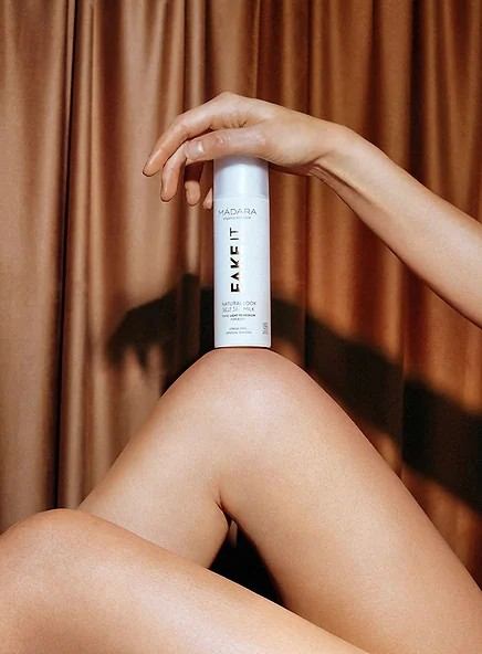 Madara Fake It Self Tan Milk – naturlig selvbruning med hyaluronsyre og jojobaolje for en jevn, solkysset glød uten skjolder.