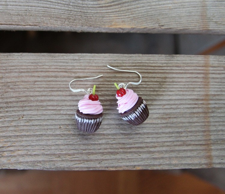 Örhängen, chokladcupcakes med rosa frosting och körsbär.