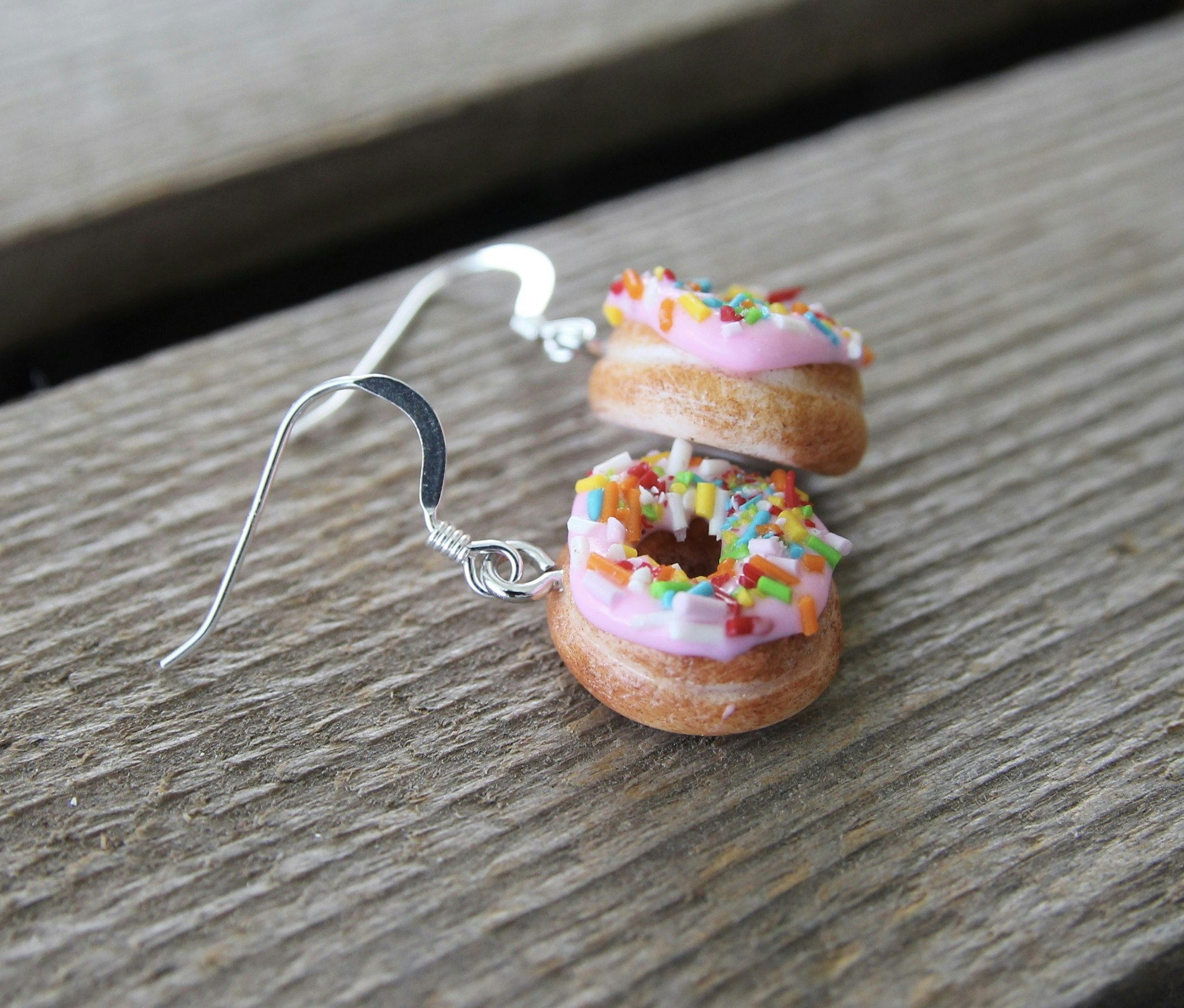 Earrings, donuts with pink icing and sprinkles without a bite
