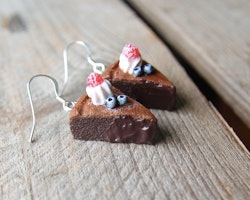 Earrings, mudcake with cream, blueberries and raspberries