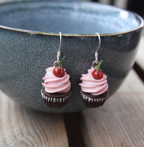 Örhängen, chokladcupcakes med rosa frosting och körsbär.