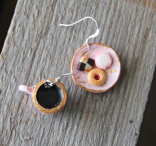 Örhängen, rosa småkakstallrik med kaffekopp