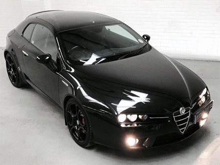 Svart Alfa Romeo med svarta fälgar och svarta stänklappar