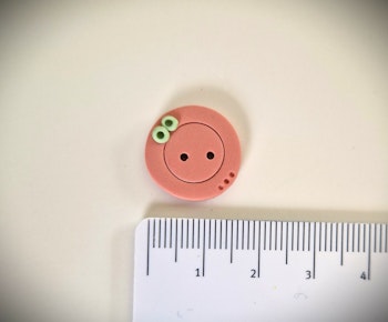 Knapp rosa med grønn detalj