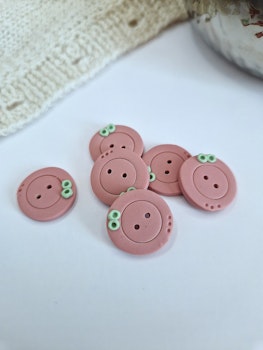 Knapp rosa med grønn detalj