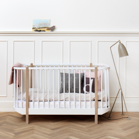 Oliver Furniture, spjälsäng vit/ek Vit/ek spjälsäng med kuddar i ett barnrum