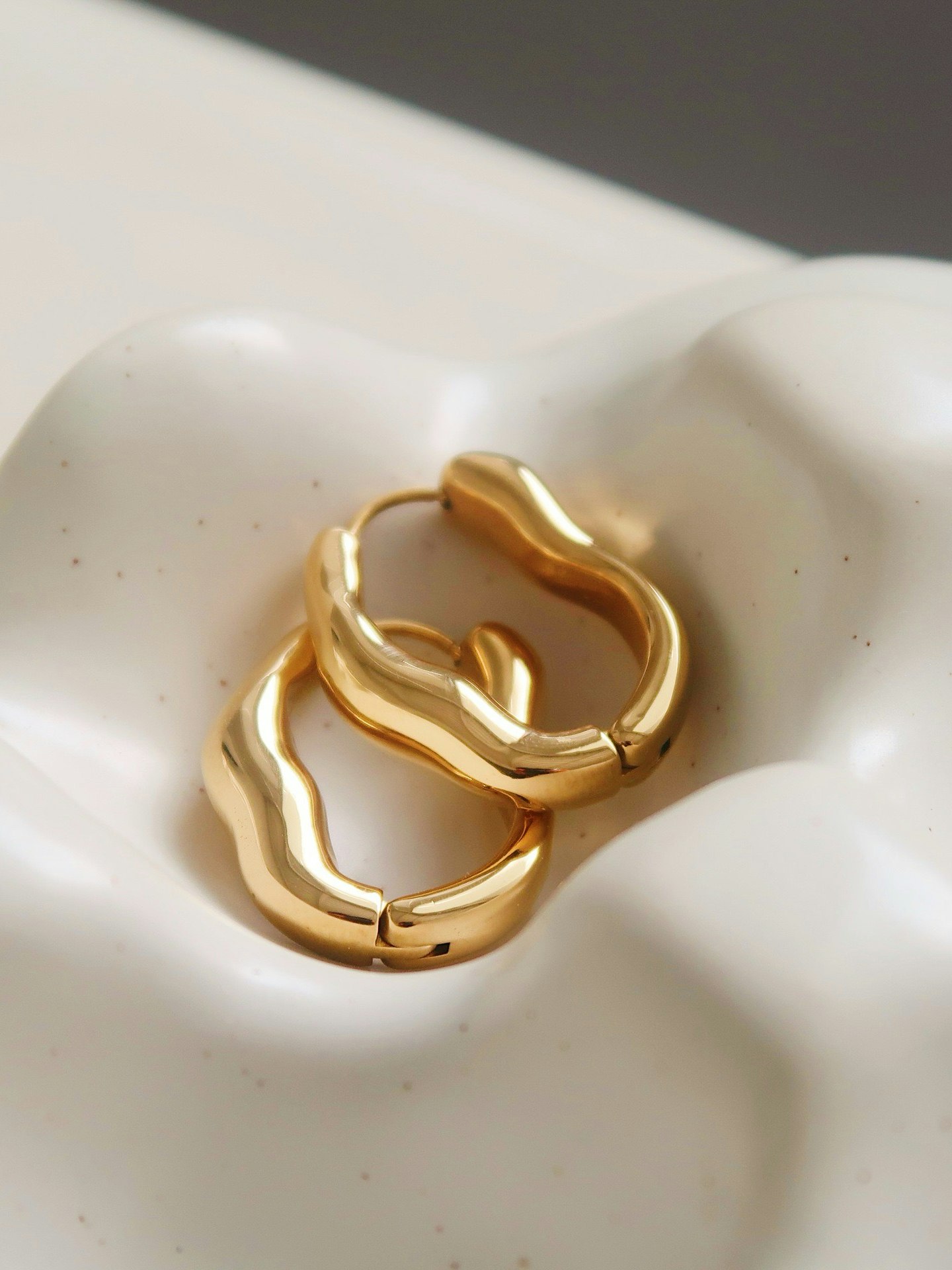 Hoops i stål med 18k guld med vågdesign