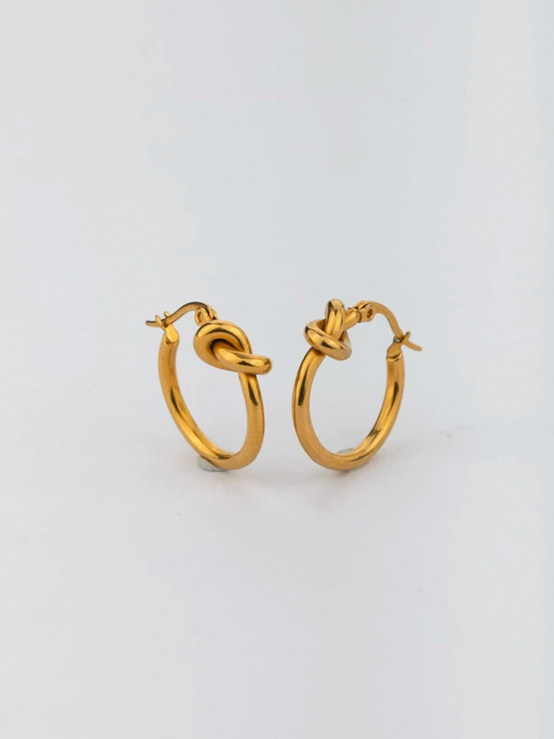 Hoops i stål med 18k guld och knut design