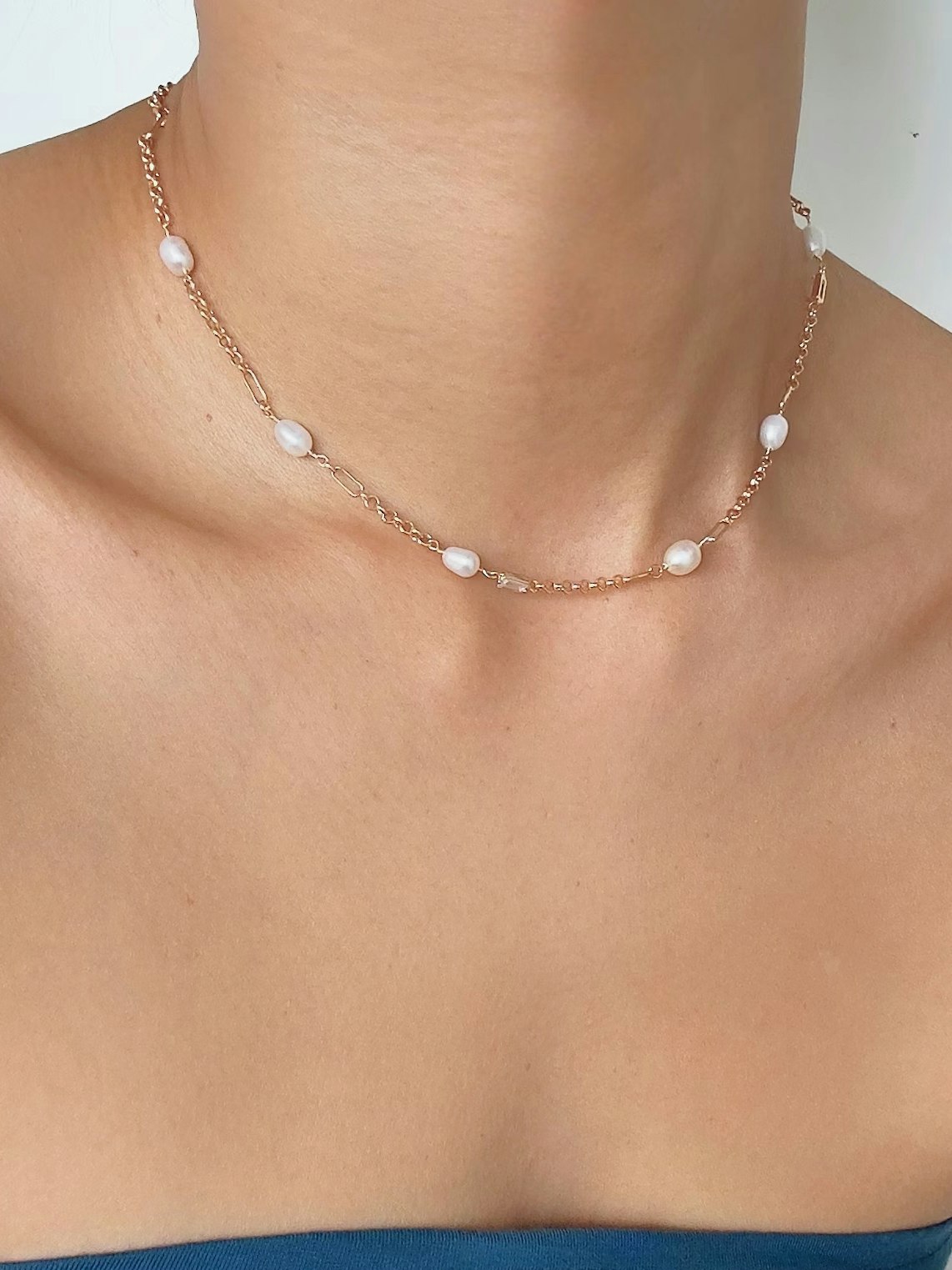 Tunt guldfärgat halsband med ovala vita pärlor