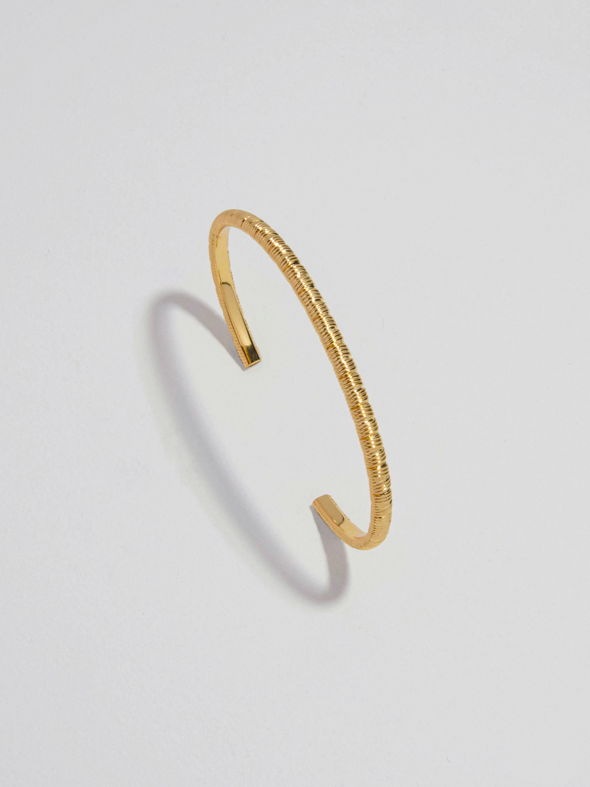 Guldfärgat bangle armband med pinstripe design