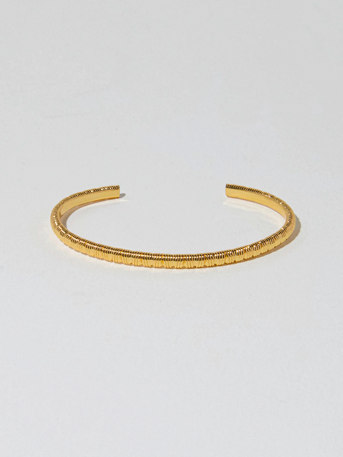 Guldfärgat bangle armband med pinstripe design