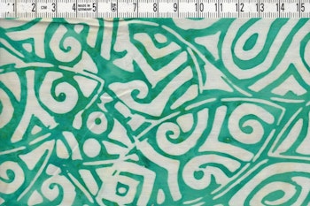 Batiktyg med grönt motiv och vit bakgrund. Bomull ca 110 cm