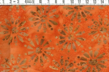 Orangemelerat med beigebruna blommor. Bomullsbatik bredd 110 cm