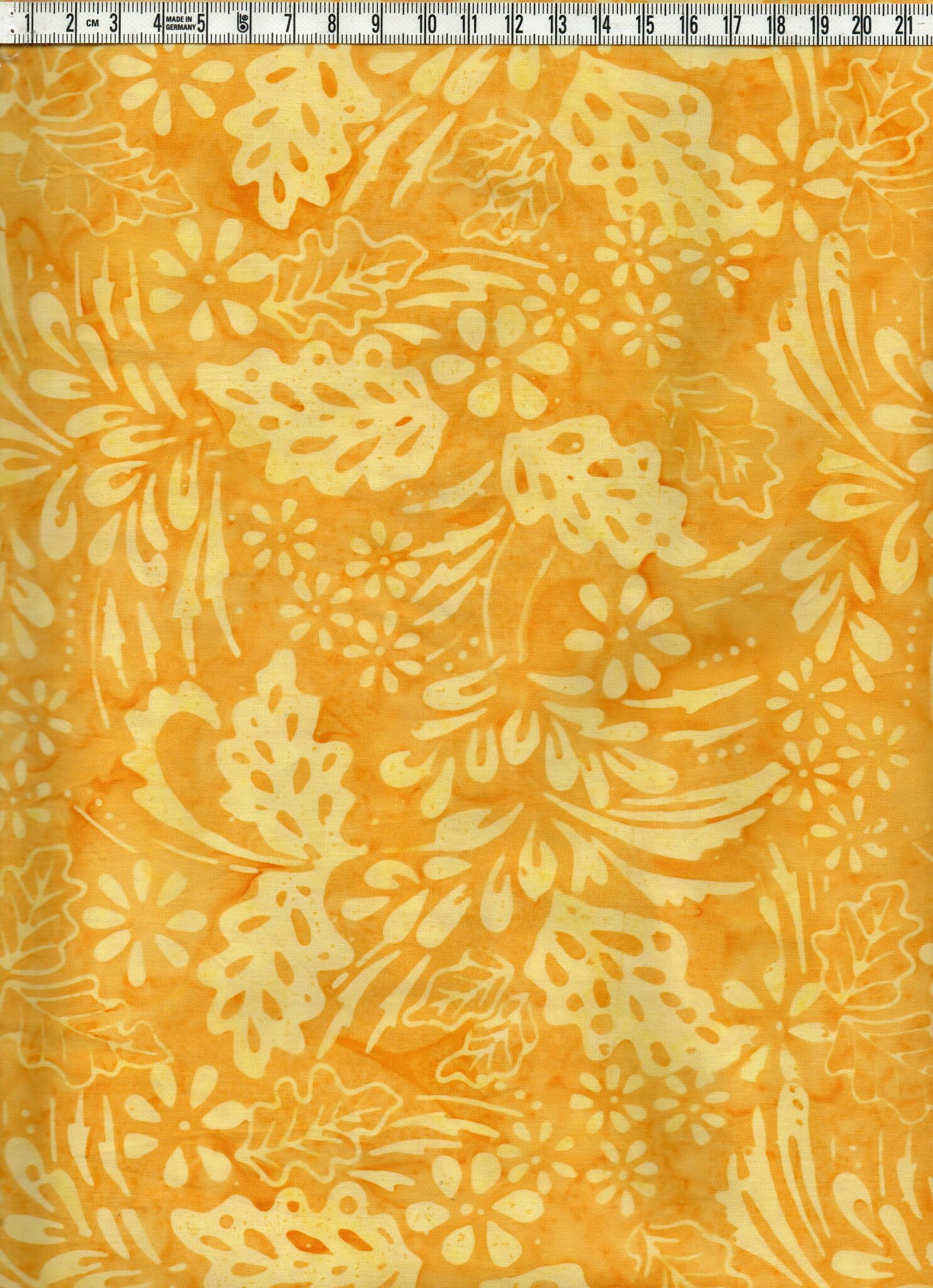 Gult med ljusare gult mönster.  Bomullsbatik bredd 110 cm