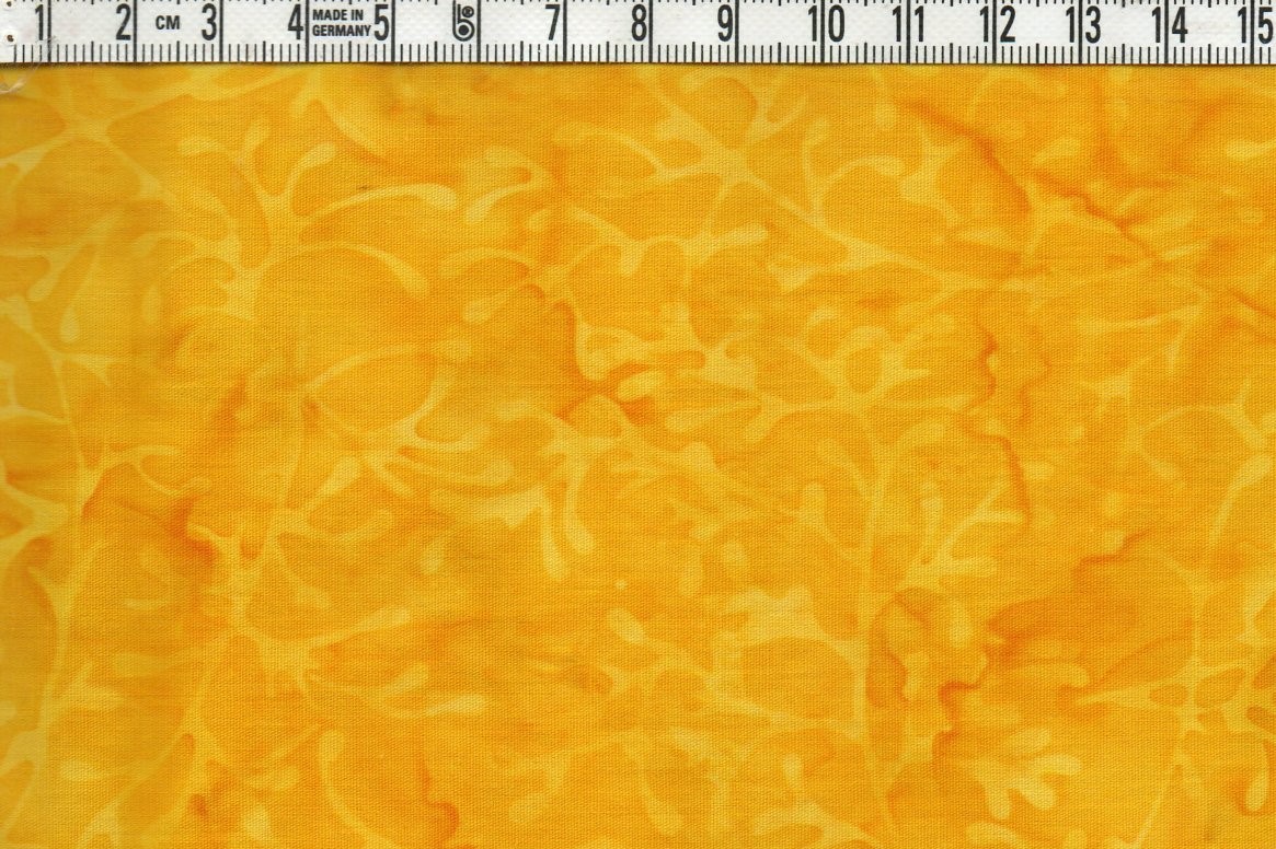 Fylligt gula färger med svagt mönster.  Bomullsbatik bredd 110 cm