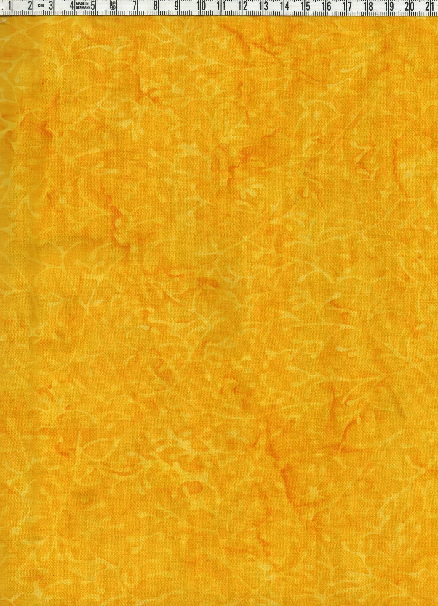 Fylligt gula färger med svagt mönster.  Bomullsbatik bredd 110 cm