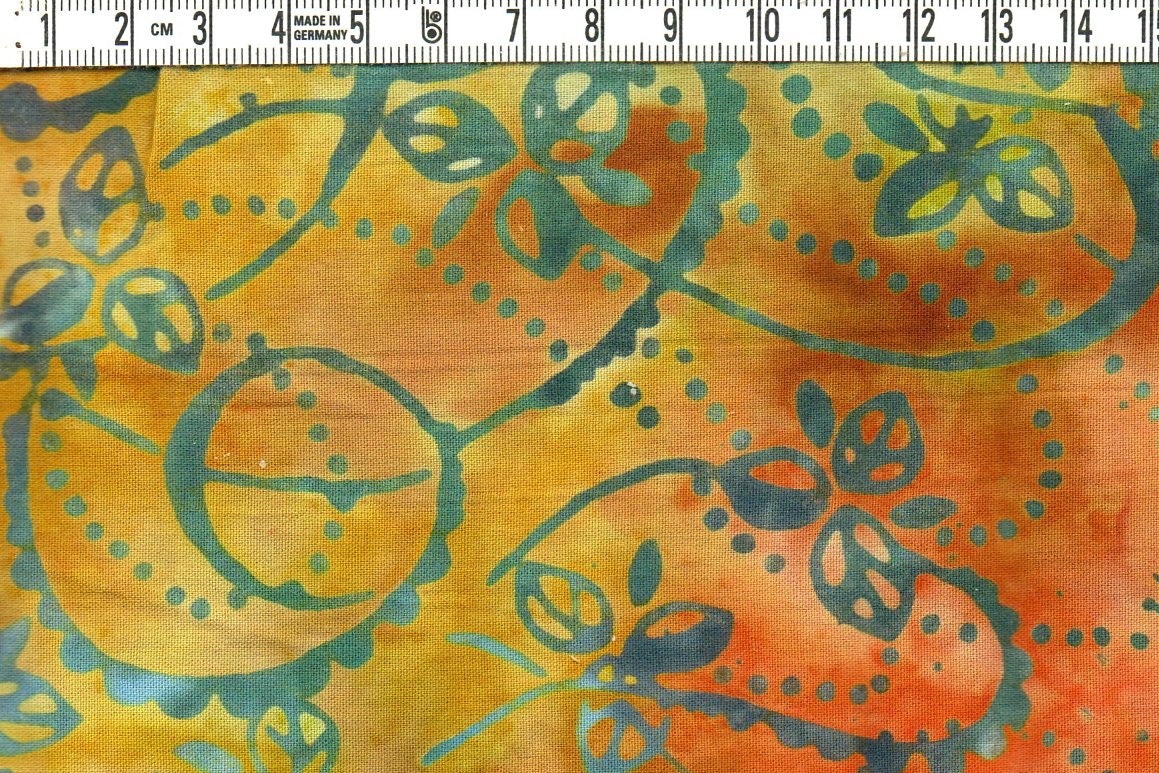 Snirkligt bladmönster i orange och grönt – Viskos Batik 110 cm bred