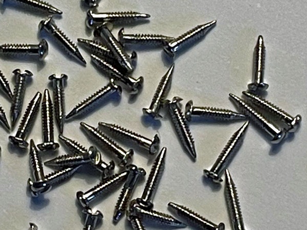 Spik/skruv, vitmetall, ca 5 mm lång