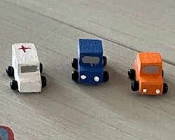 Tre bilar, vit, orange och blå
