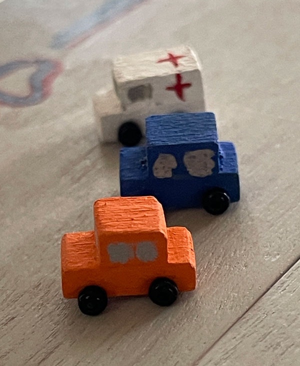 Tre bilar, vit, orange och blå