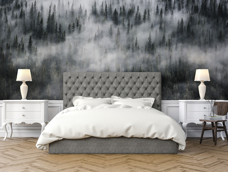 Säng framför en vägg med fototapet av dimmig skog.