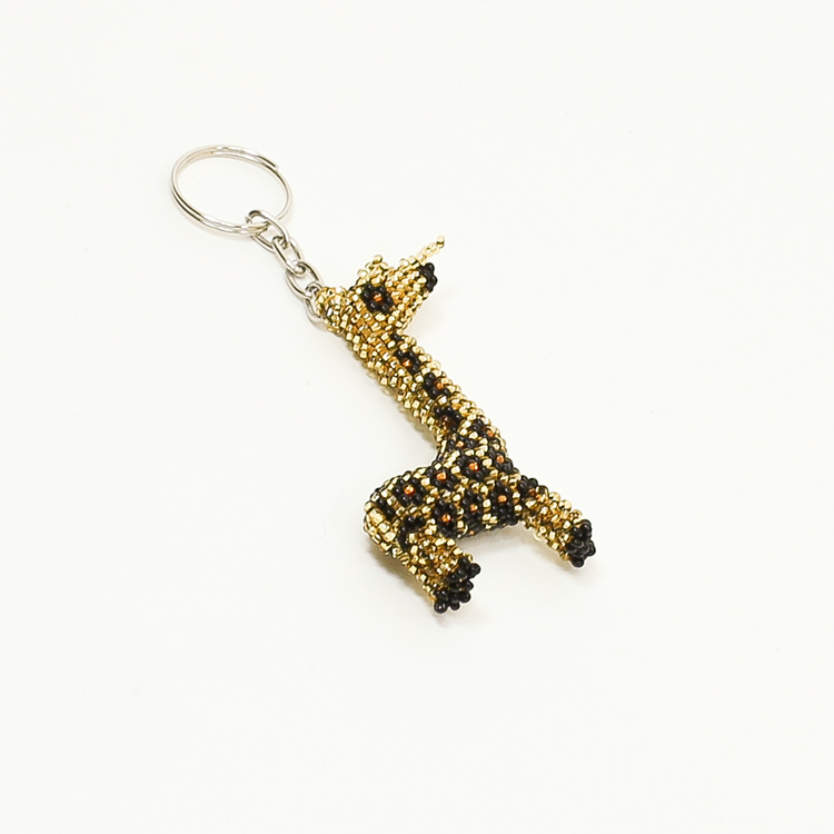 Nyckelring med djurmotiv i form av en giraff. Gjord av många, mycket små glaspärlor. Giraffen är gul och svart, handgjord och rättvist handlad.