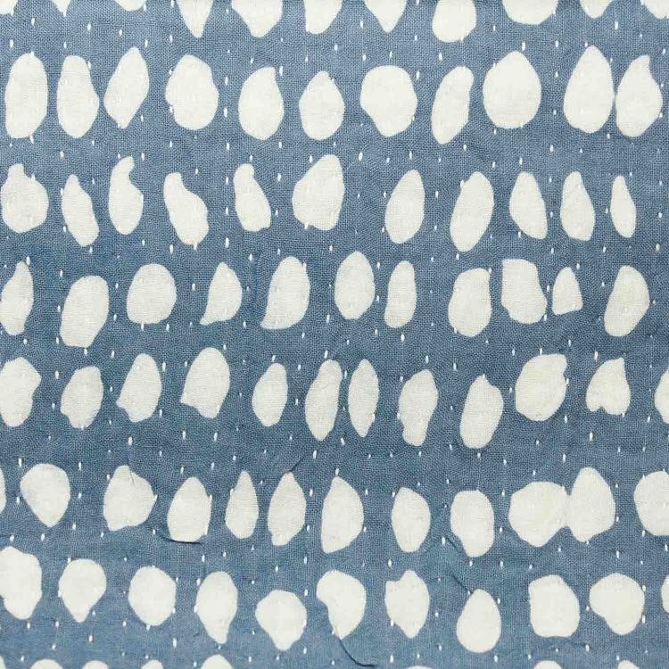Kudde med mönster av vaxbatik i blågrå och vitblå färg. Närbild.