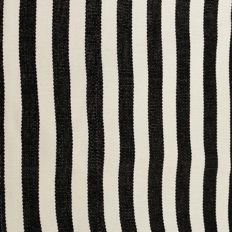 Närbild. Kuddfodral i handvävd bomull, svart och benvitt mönster.