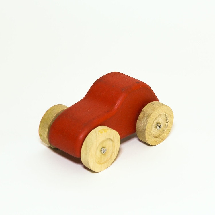 Leksaksbil i trä, röd. hjulen i natur. Formen: personbil.