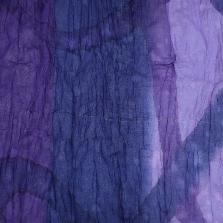 Stor färgstark sjal i krinklad bomull, lila och blå nyanser, med små vita stäng. Detaljbild.
