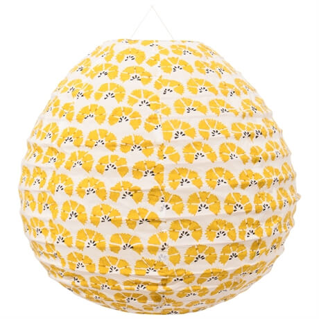 Lampskärm i tyg i oval droppform med gult mönster på vit botten.