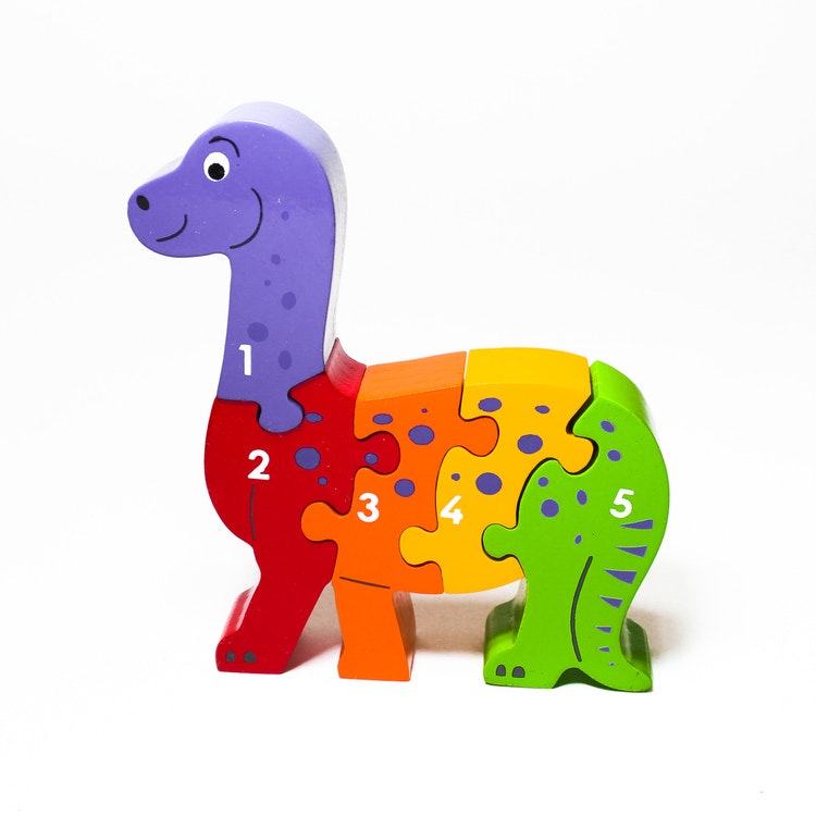 Snäll , färgglad dinosaure som träpussel, med siffrorna 1 -5 på ena sidan. Rekommenderas till barn äldre än 1 år. giftfria färger. Fair Trade.