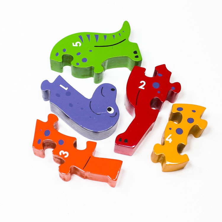 Snäll , färgglad dinosaure som träpussel, med siffrorna 1 -5 på ena sidan. Här är pusslets delar inte sammansatta. Rekommenderas till barn äldre än 1 år. giftfria färger. Fair Trade.