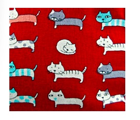 Enkel röd necessär med små roliga katter. Bomull. Insidan impregnerad. Närbild på kattmotiven. Fair Trade från Thailand.