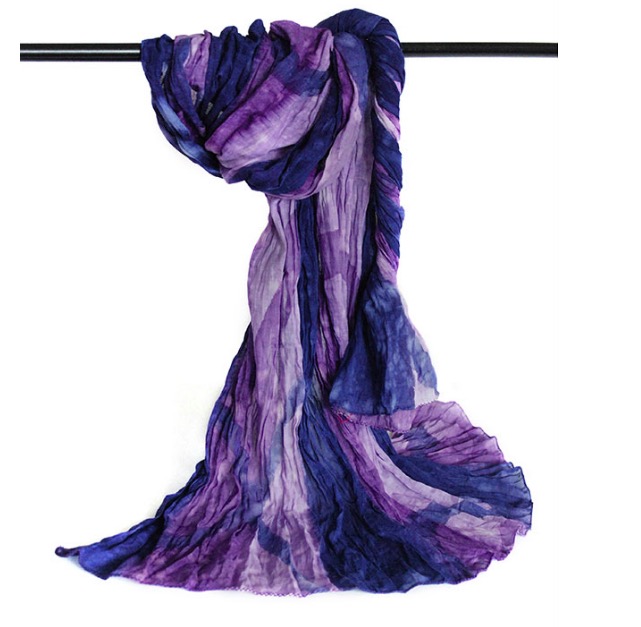 Stor färgstark sjal i krinklad bomull, lila och blå nyanser, med små vita stäng. Fair Trade.