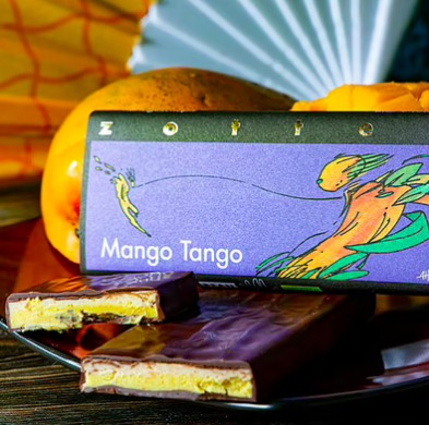 Zotter Mango Tango, exklusiv handgjord chokladkaka med ganache av mango och citron. Fair Trade, ekologisk, bean-to-bar. Bild med dekoration.