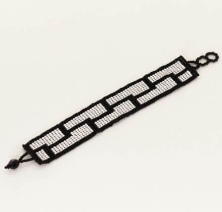 Smycke: armband av mycket små glaspärlor i vit & svart. Mönstret påminner om en vacker tegelstensmur i två rader.
