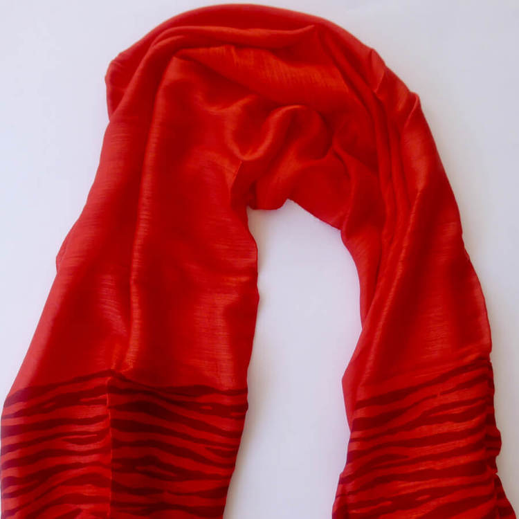 Sjal eller scarf i klarröd färg med zebra-mönster. Material viskos & siden/silke.Handvävd för Fair Trade i Vietnam. Detaljbild.