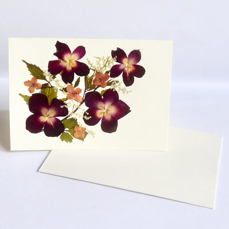 Vikt kort av återvunnet papper med torkade vild växande blommor, violer. Handgjort, Fair Trade.